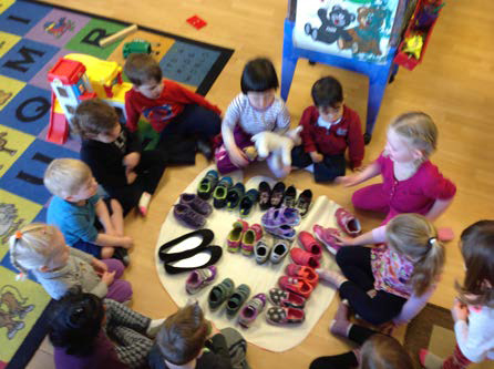 children seeing how many of their shoes fit in a dino paw print