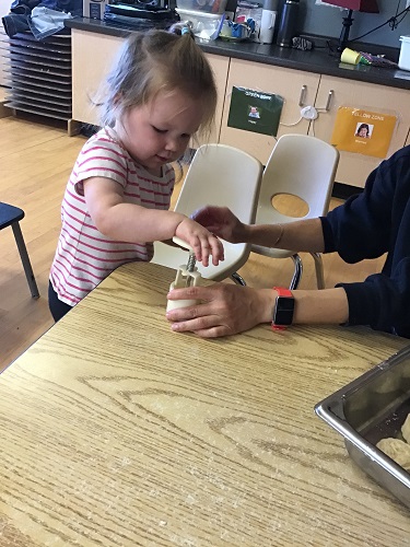 Child using mold to press mooncake cookies