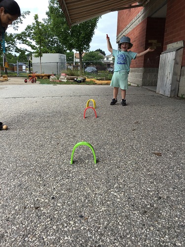 Preschool child playing croquet 