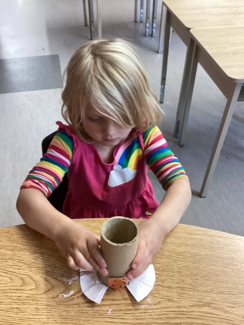 child putting a top onto their maraca