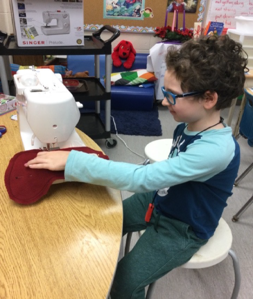 child sitting on the floor beside some wood stumps