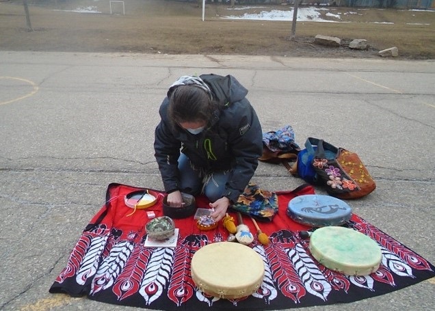 guest displaying indigenous culture items on a blanket