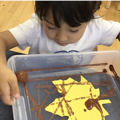 Child engaged in marble painting.