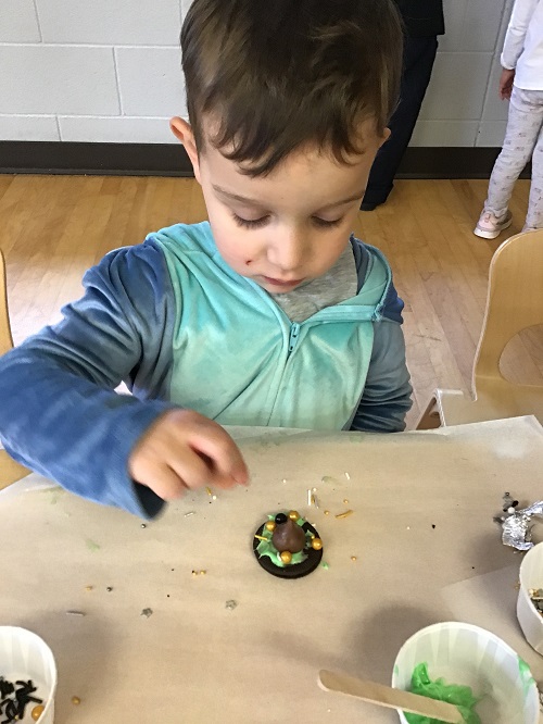 Child making Oreo witch hat as a snack.