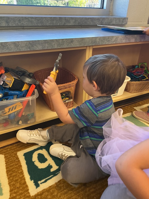 Child putting toy back in the basket.