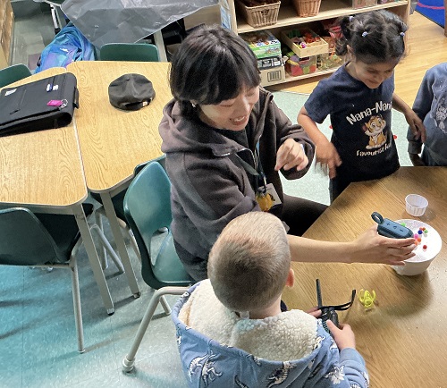 Educator showing group how to put the speaker close to the bowl.