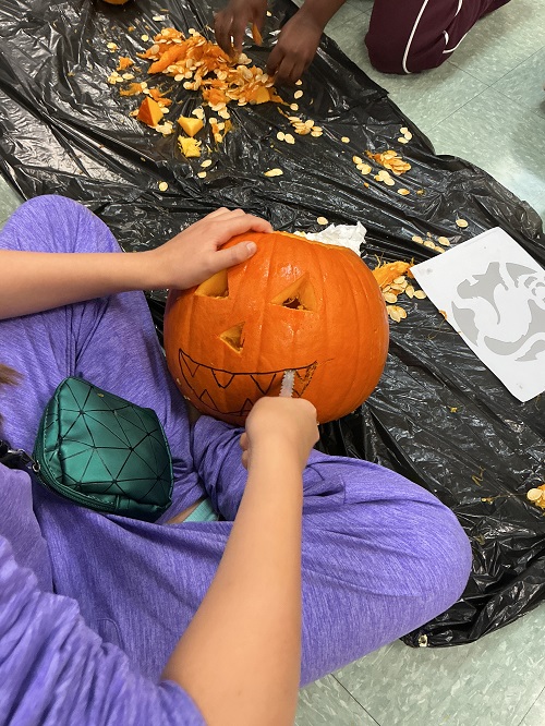 Child carving out a pumpkin