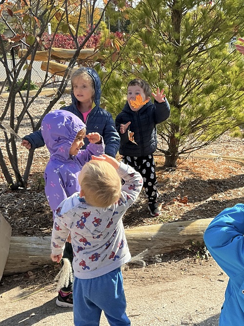 Children throwing leaves up in the air.