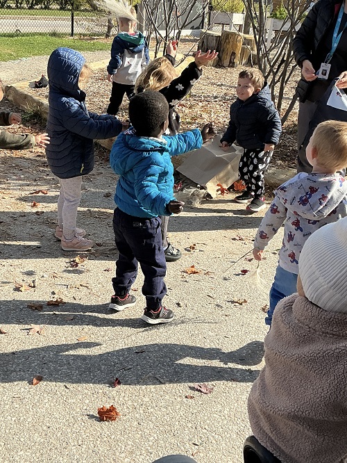 Children throwing leaves up in the air.