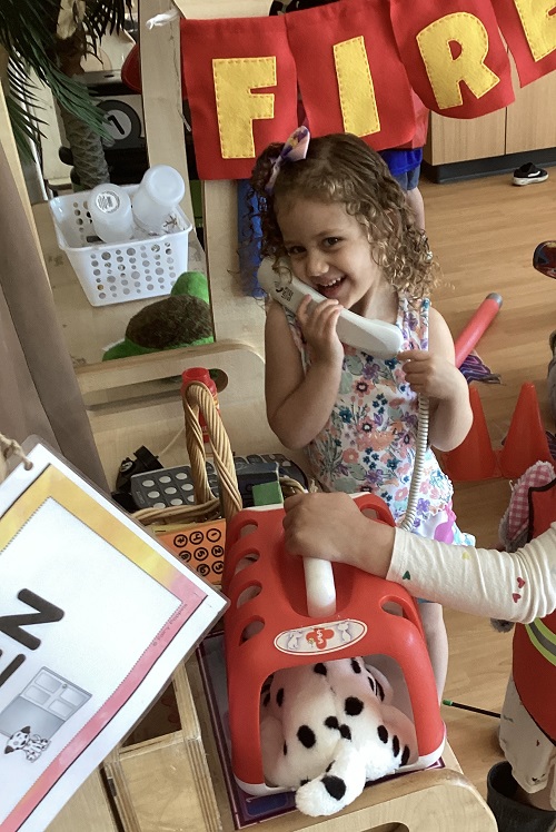 A preschool child on the phone in the fire station