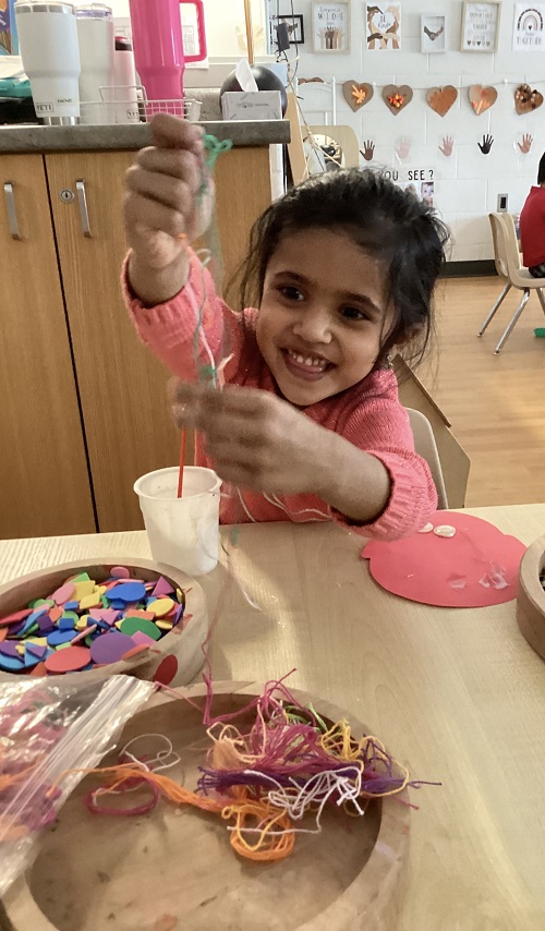 A preschool child holding string