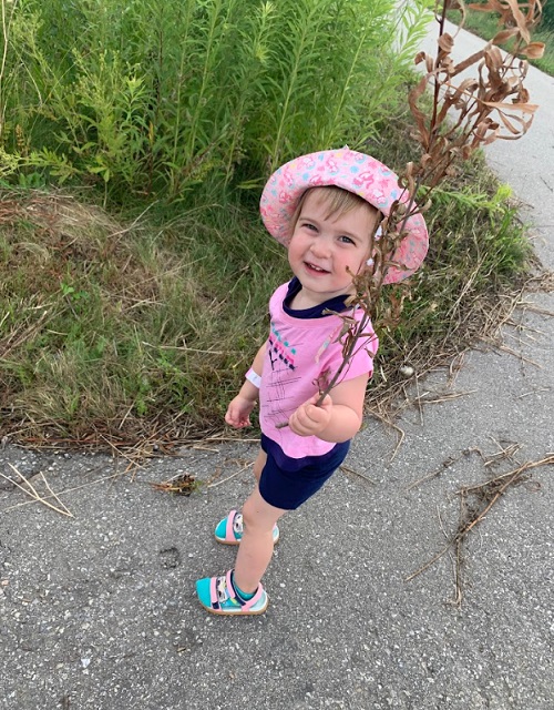 A child holding up a treasure they found on their journey.