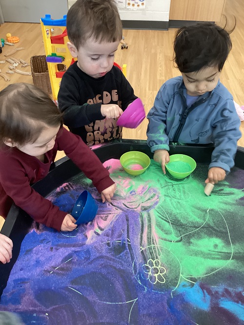 Toddler children playing with colourful sand for Holi