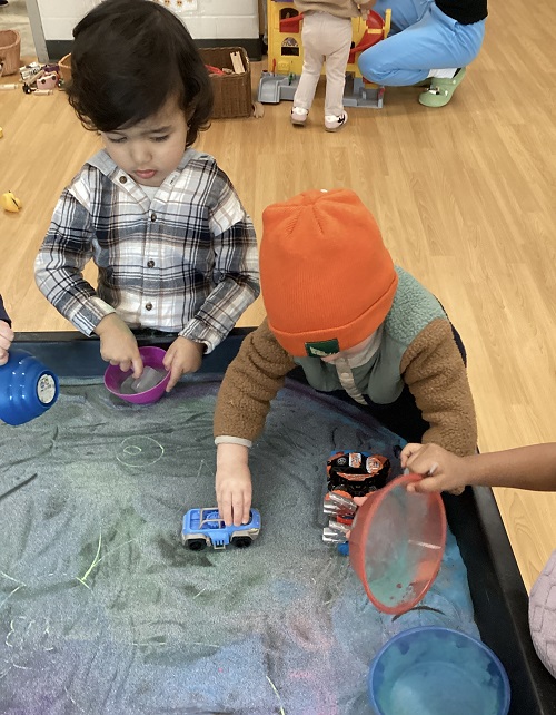 Toddler children playing with colourful sandfor Holi