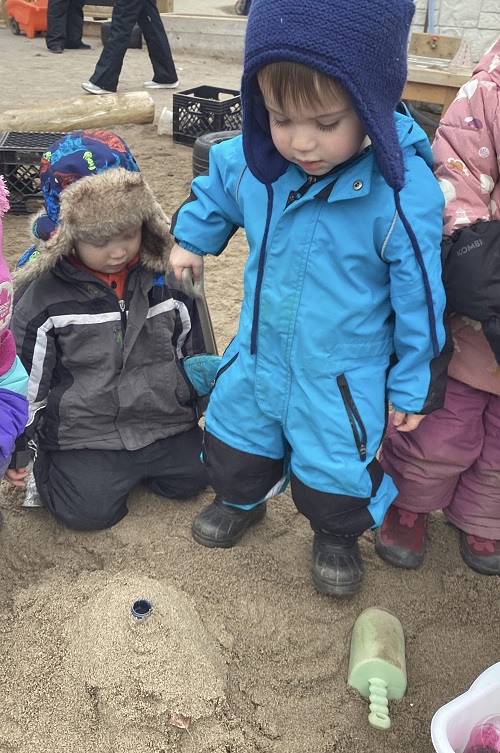 A small group of children observing the volcano they created