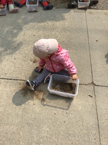 Child play with sand in a bucket 