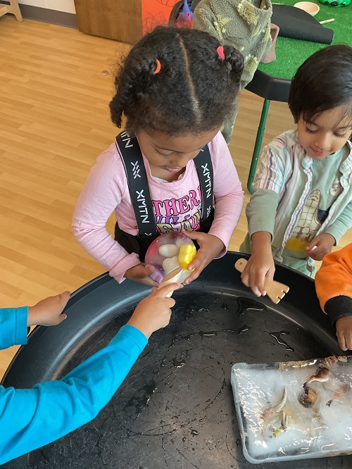 child holding ice, while another scrapes it