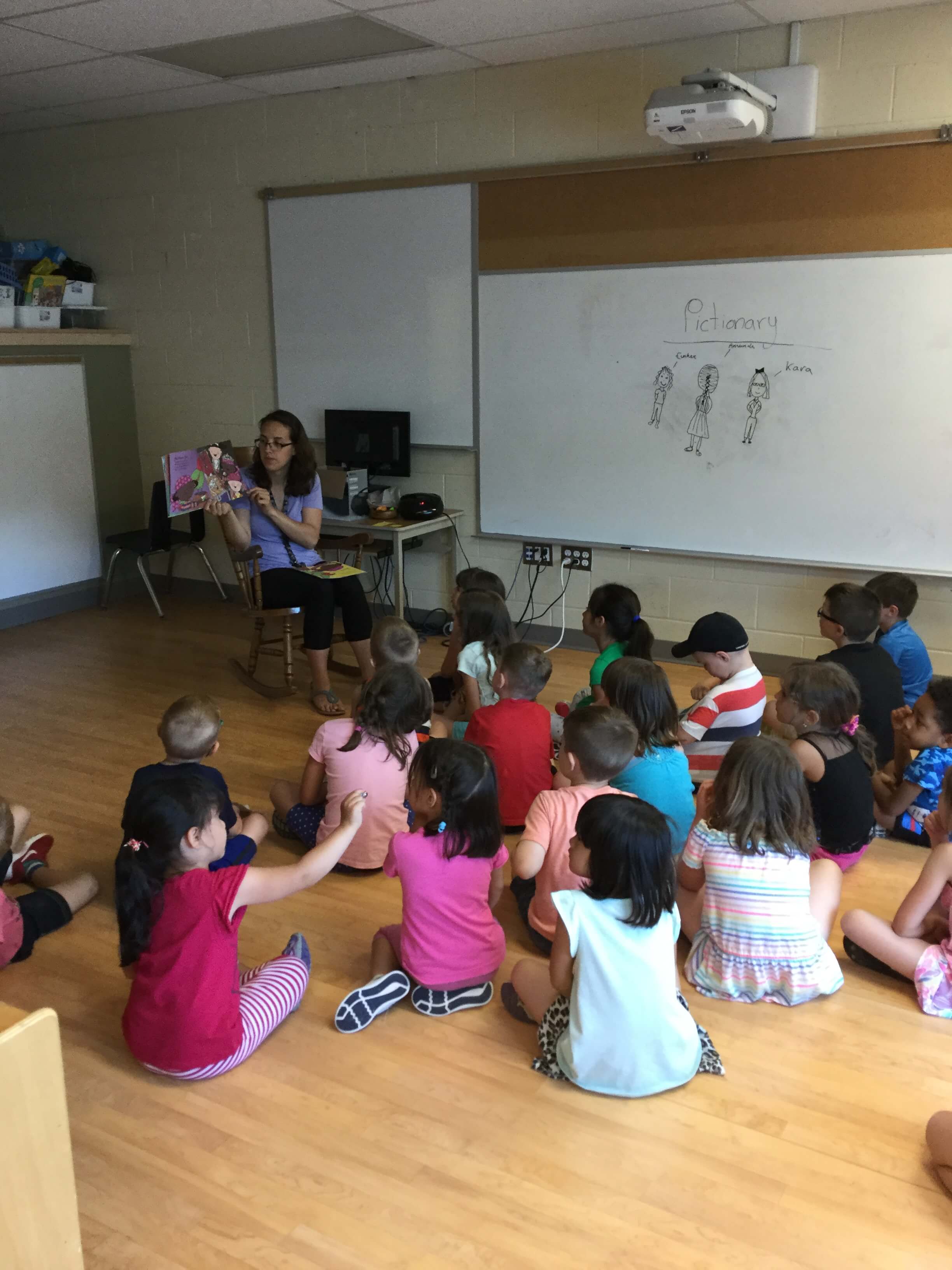 children listening to a story read by an educator