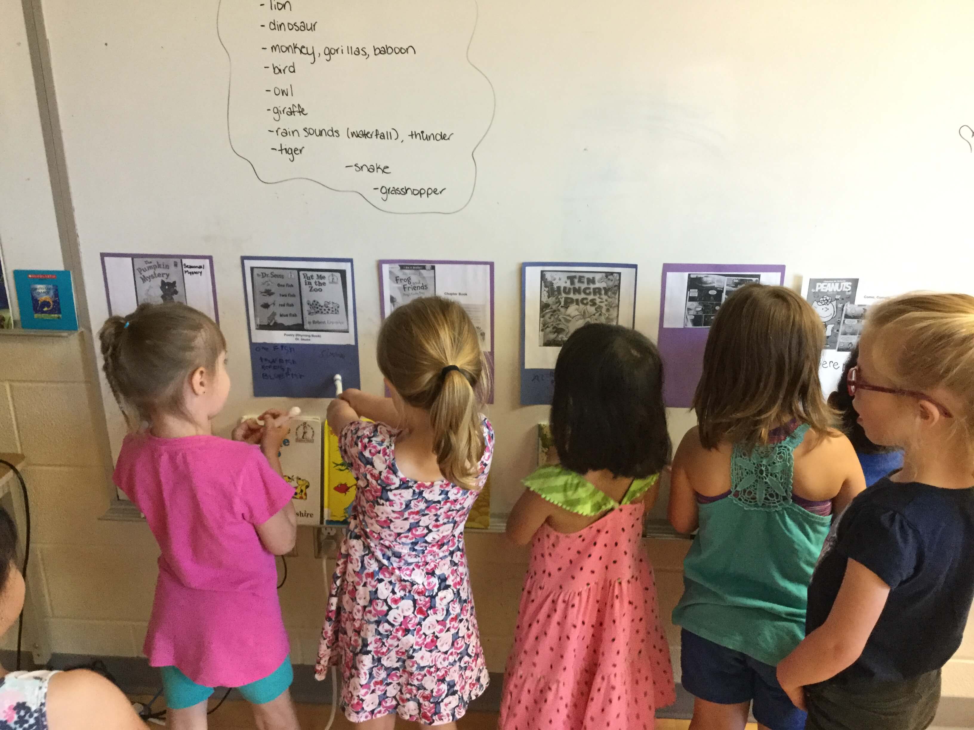 children posting their work on a board