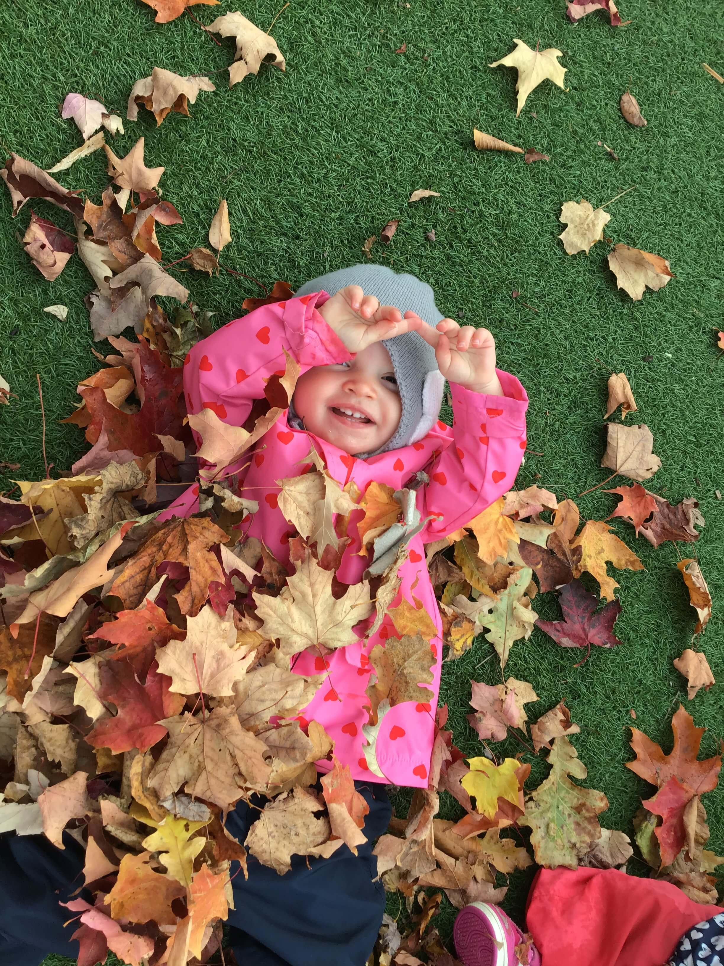girl playing in leaves