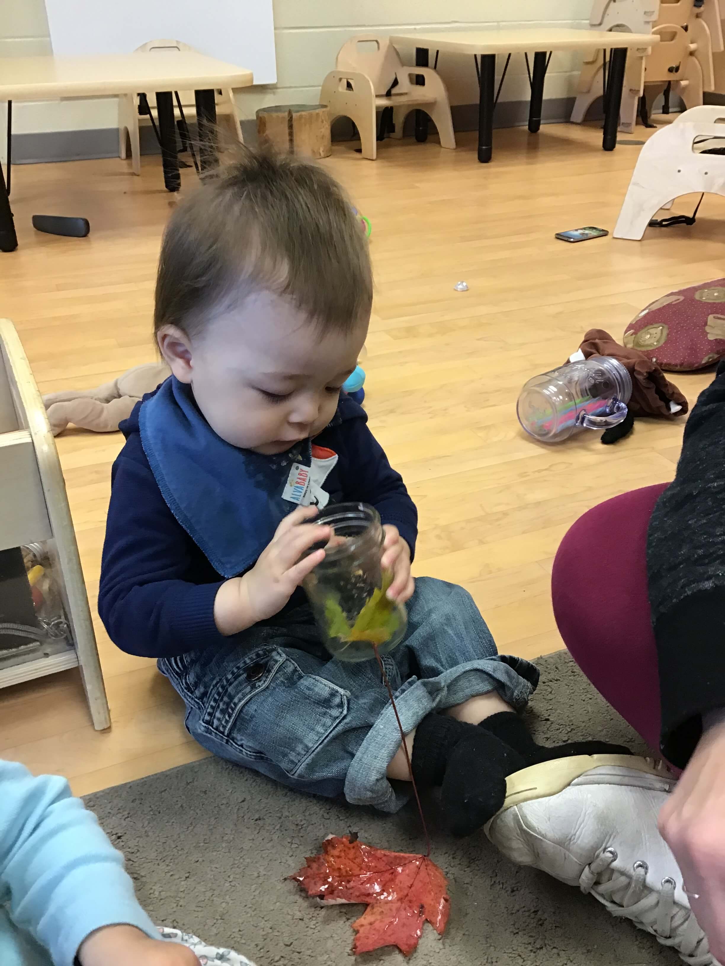 boy holding a jar of leaves