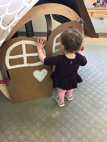 A child opening the doors of a big ginger bread house
