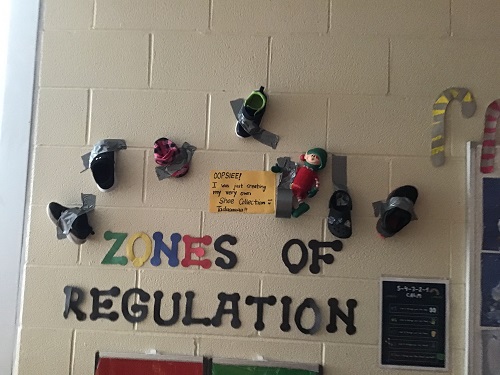 Children's shoes duct taped to the classroom wall