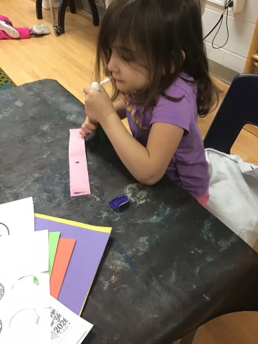 A child writting on a strip of paper