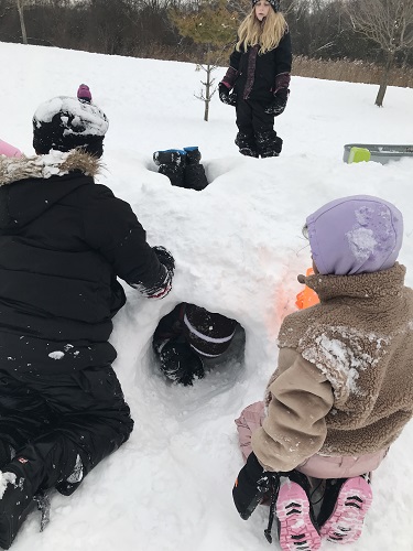 Children digging tunnels in the snow