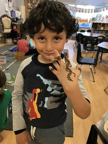 A school aged child showing the Henna painted on his hand