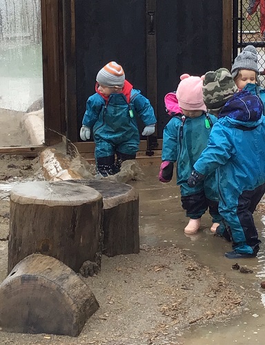 Toddlers exploring in puddles