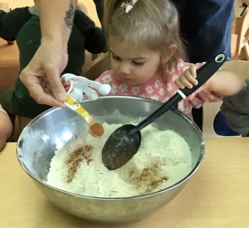 A child mixing flour in a big bowl